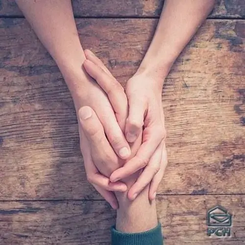 6 Hai bàn tay đan chặt vào nhau trên mặt bàn gỗ thô mộc thể hiện sự gắn kết bền chặt và chỗ dựa bình yên lúc gặp khó khăn.
