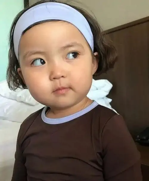 24 Meme hài bé gái đeo băng đô xanh mặc áo nâu đang liếc ngang với vẻ mặt không hề ấn tượng trước câu chuyện của người đối diện.