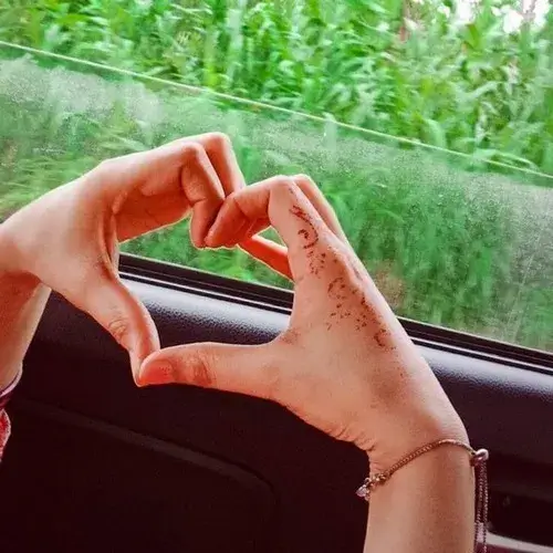 6 Đôi tay áo trắng tạo hình trái tim bên cửa xe, phía ngoài là mảng xanh khiến cảnh thả tim khá dịu