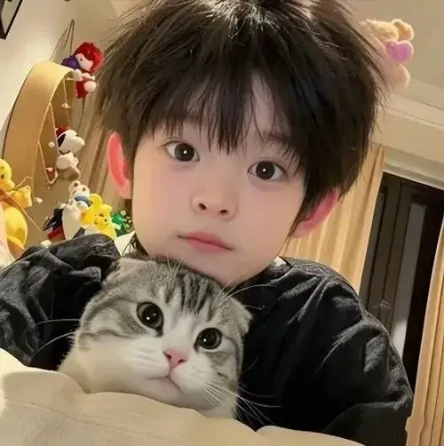 11 Cậu nhóc tóc rối ôm mèo trong phòng, đôi mắt mở to làm cả người lẫn mèo đều như đang bị bắt quả tang