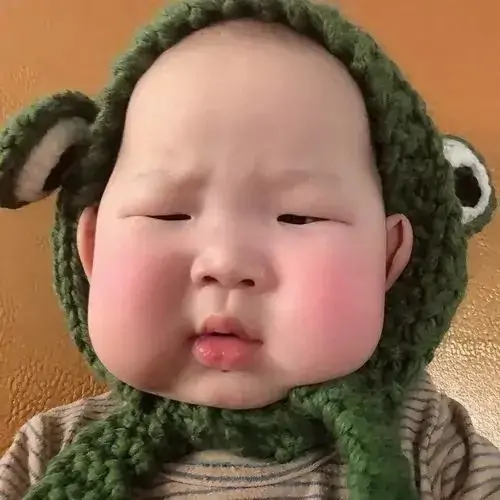 21 Gương mặt tròn trong mũ lông xanh làm bé trông như thú bông đang dỗi, đôi má căng lên rất buồn cười