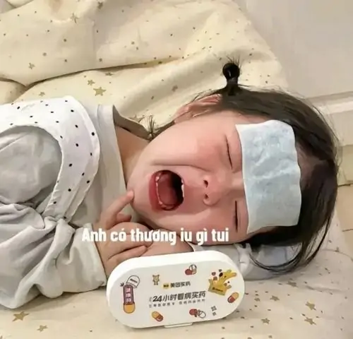 23 Em bé nằm trên giường khóc đỏ mặt, chiếc khăn trắng và dòng chữ nhỏ khiến cảnh dỗ dành trở nên rối nhẹ