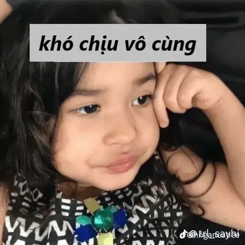 20 Ảnh vui bé gái tóc buộc hai bên chống cằm nhìn sang một bên với ánh mắt dò xét đầy hoài nghi và hậm hực.