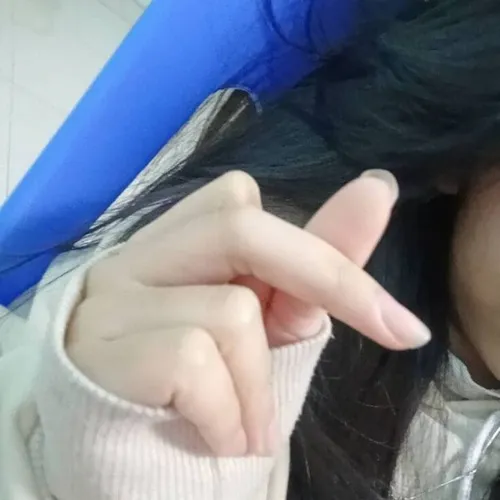 27 Cận cảnh hai bàn tay bên tay áo xanh chụm ngón thành tim, nền bàn làm việc khiến tình huống trông rất đời thường