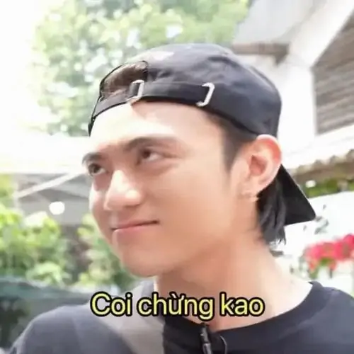 29 Chàng trai đội mũ ngược nhìn lệch sang bên, dòng chữ “Coi chừng cao” khiến cú chỉ tay ngầm thành lời cảnh báo.