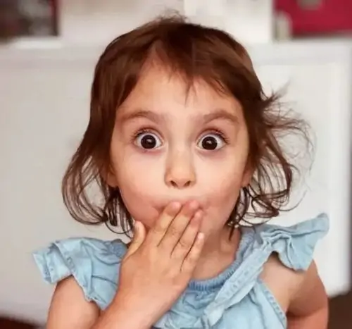 35 Em bé áo xanh tròn mắt và chu môi giữa nền tối, biểu cảm ngạc nhiên lặp lại nhưng vẫn hợp cảnh bị hỏi bất ngờ