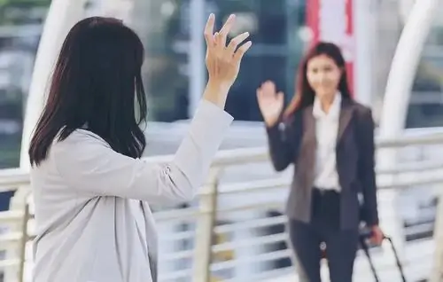 18 Tạo nên một hình chế chào nhé đầy thực tế với bức ảnh hai cô gái mặc trang phục công sở đứng vẫy tay chào nhau trên cầu đi bộ.