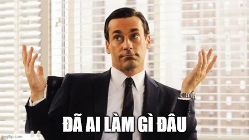 13 Người đàn ông mặc áo vét đen ngồi giữa phòng sáng, hai tay nhún vai làm câu đã ai làm gì đâu thêm sang chảnh