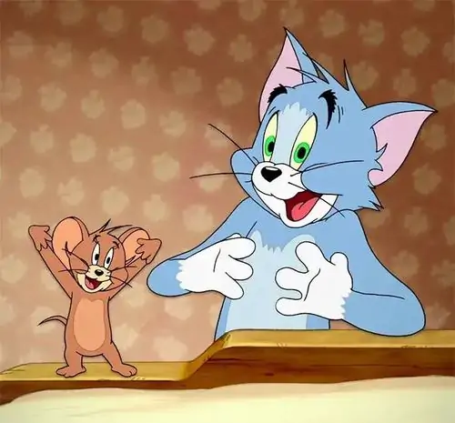 22 Tom đặt tay lên ngực nhìn Jerry với vẻ bối rối, ánh mắt xanh lá phóng đại cảm giác bị bắt bài trong cuộc trò chuyện