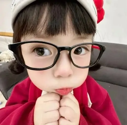 29 Chiếc kính đen trên mặt bé gái áo đỏ làm cái bĩu môi thêm nghiêm trọng, nhìn như đang học làm người lớn
